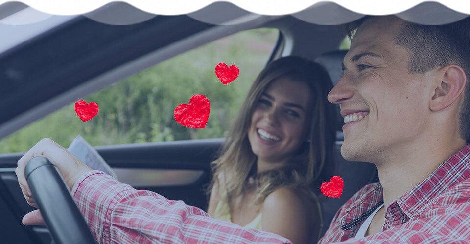 Man and woman smiling in car