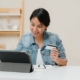 Woman looking at computer while holding credit card in hand