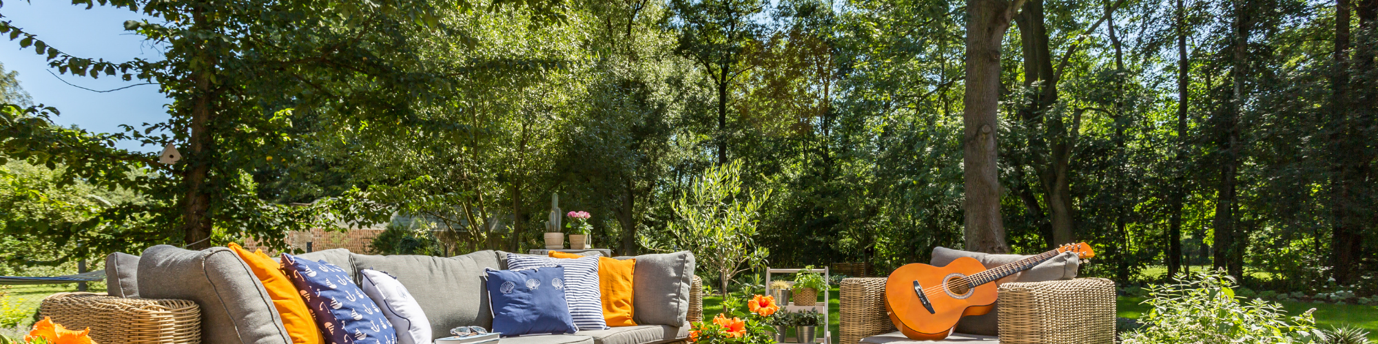 Outdoor patio with furniture, bright pillows and large backyard