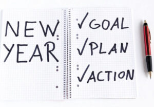 Notebook with New Year written on the left and Goal, Plan, Action listed on the right