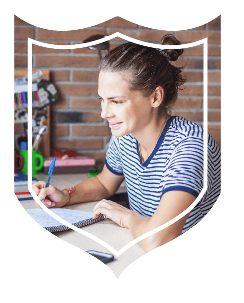 Lady diligently working at desk while writing in notebook with pen.