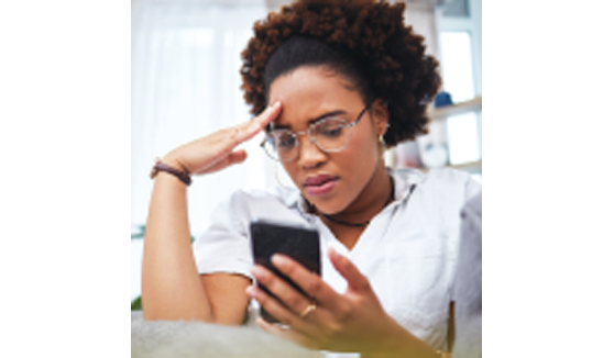 Frustrated woman looking at cell phone.