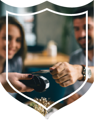 Man and woman sitting at table in restaurant paying waitress with credit card