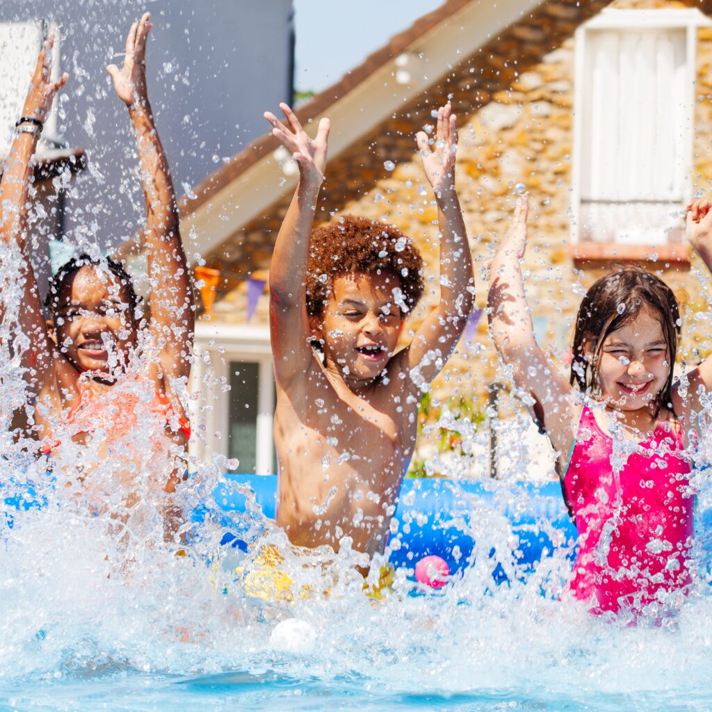 3 Kids splashing in a pool