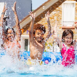 3 Kids splashing in a pool